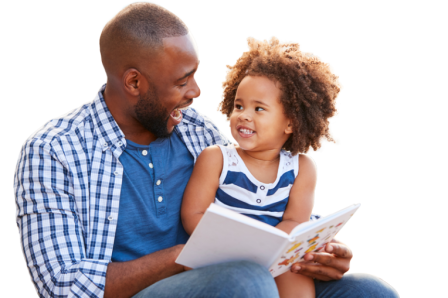 A Black father smiles while holding his young daughter. They are reading a book together.